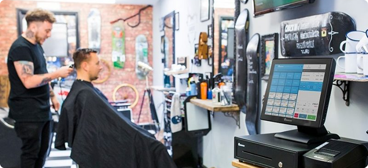 Barber styling a client's hair at a modern salon counter